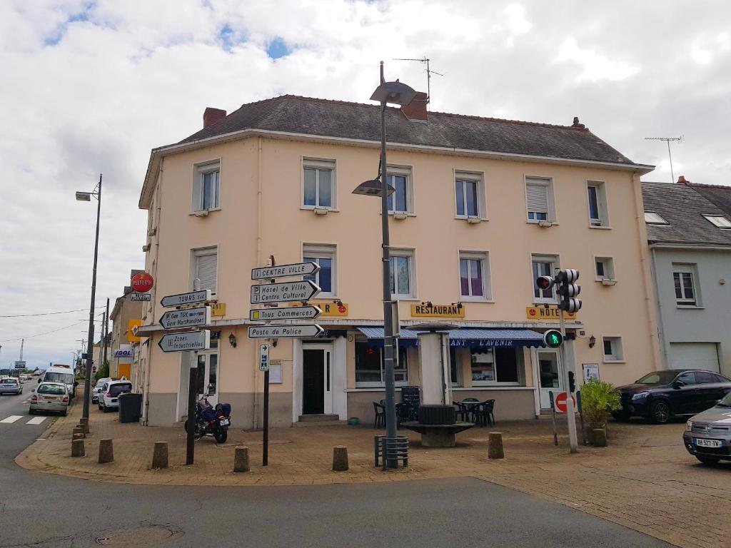 圣皮耶尔代科尔普Hotel Restaurant l'Avenir的建筑前有路标的柱子