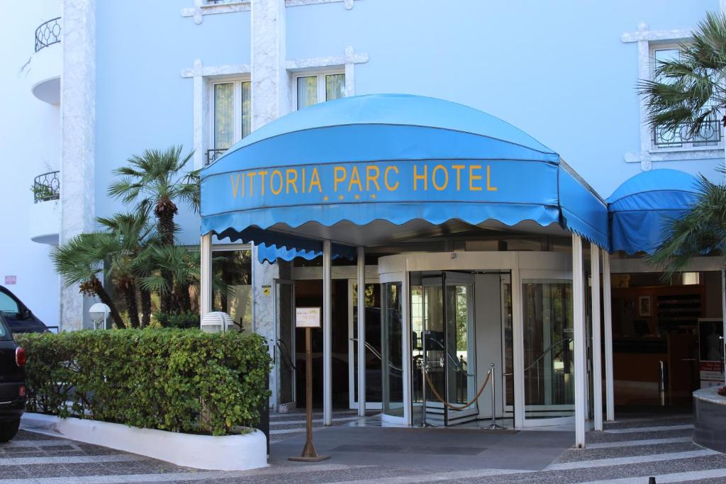 巴里维多利亚公园酒店 的建筑前有蓝色遮阳篷的酒店