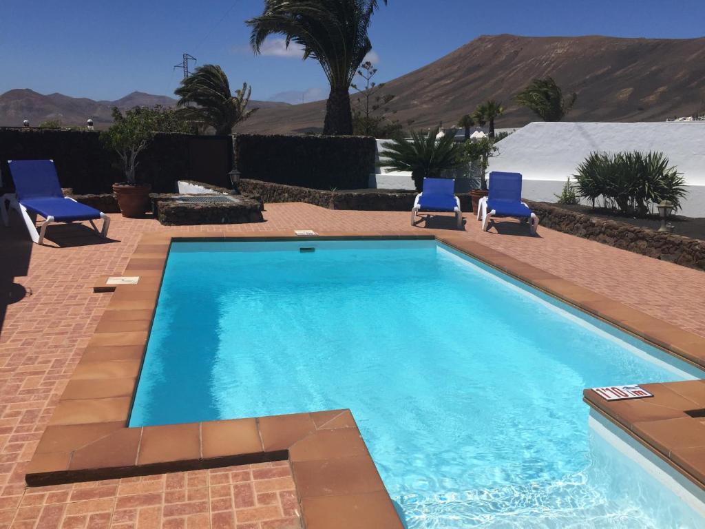 马赫Villa Lucky - Heated Pool的一个带蓝色椅子的游泳池,背景是山脉