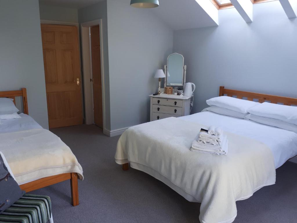EastringtonField View B&B的一间卧室配有两张床、一把椅子和镜子