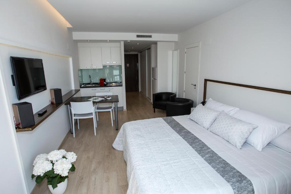 奥利瓦奥利瓦海滩公寓酒店的一间带白色大床的卧室和一间厨房