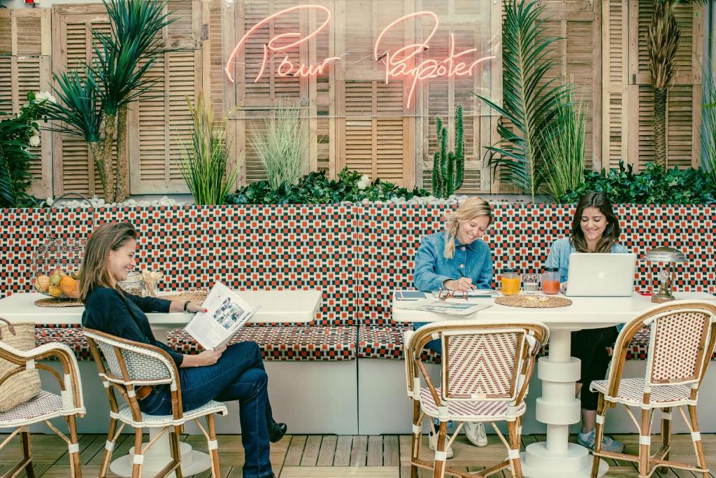 巴黎Bob Hotel的三名妇女坐在餐厅桌子旁,手提电脑