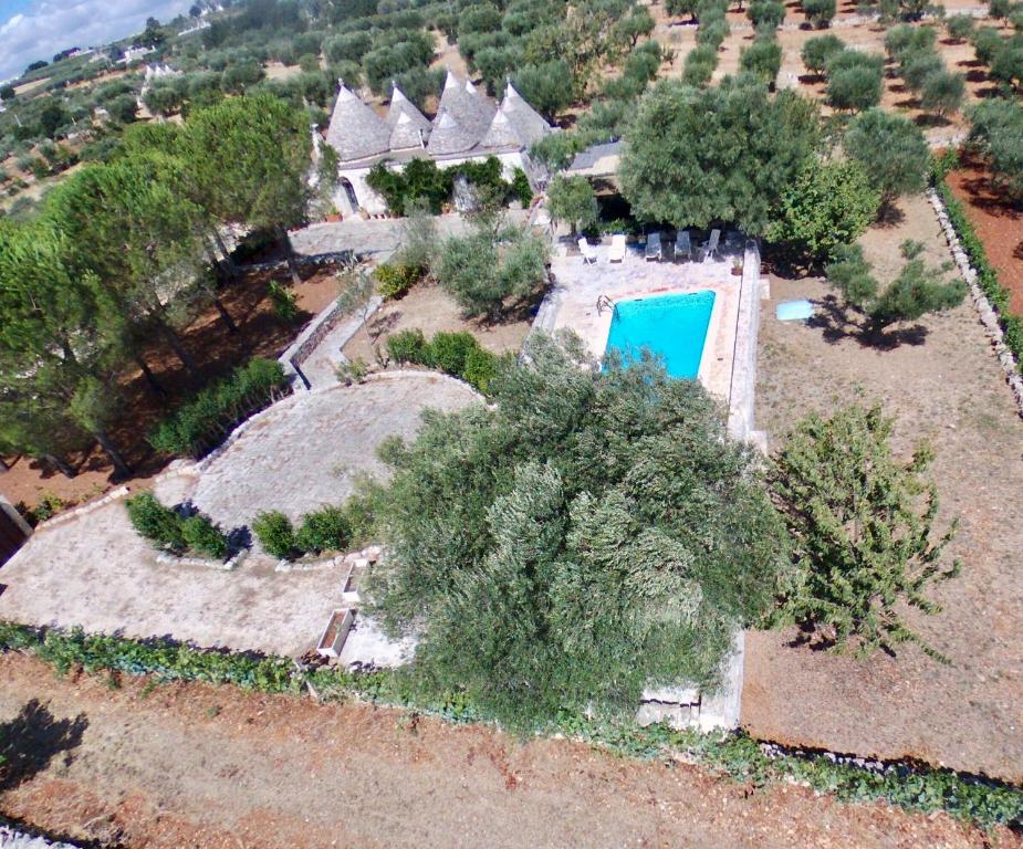 洛科罗通多Trullo Dimora della Valle的享有带游泳池的房屋的空中景致