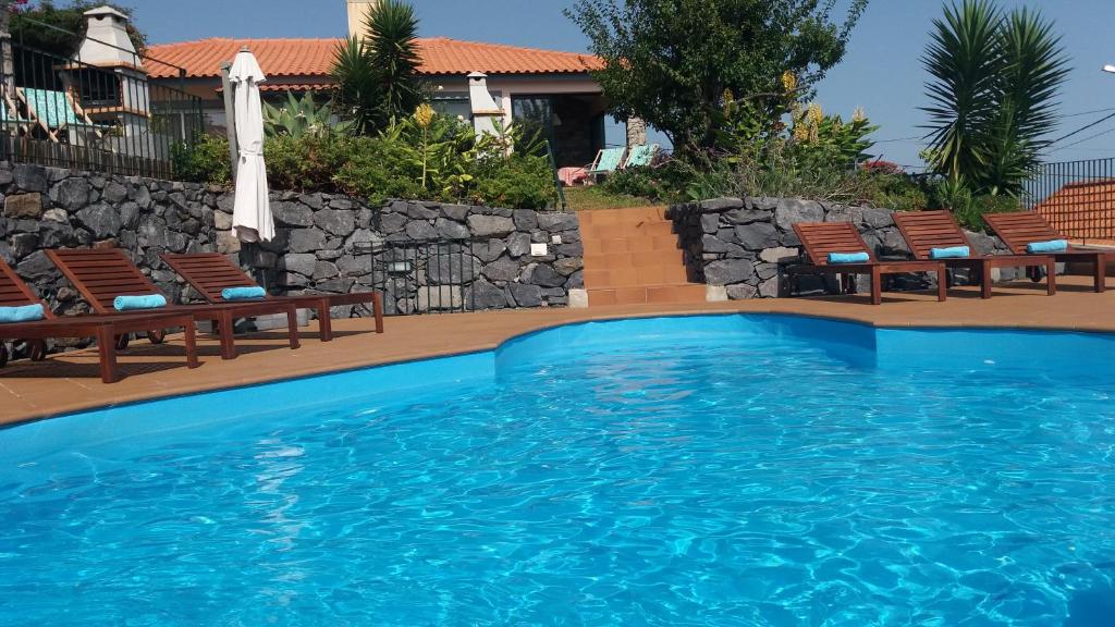 伊斯特雷托达卡耶塔Banda Do Sol Self Catering Cottages的一个带椅子和遮阳伞的游泳池