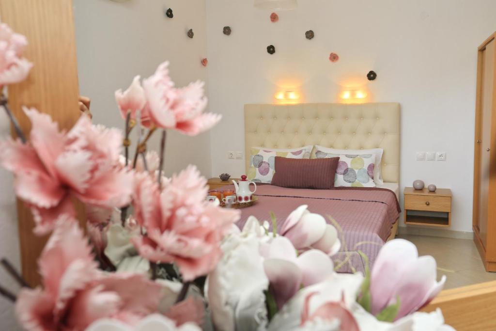卡尼奥提Kastoria Hotel Apartments的一间卧室,前方设有一张粉红色鲜花的床