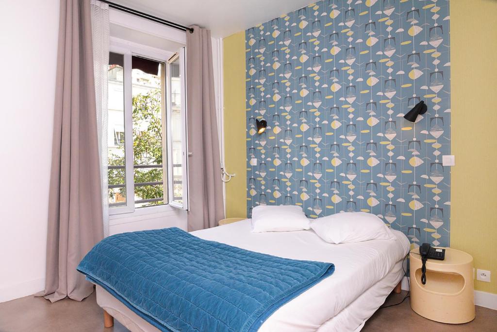 巴黎赛斯酒店的一间卧室配有一张蓝色墙壁的床