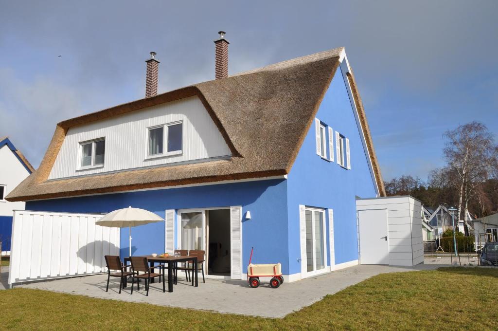 布雷格Ferienhaus Wiekhus的蓝色和白色的房子,配有桌子和椅子
