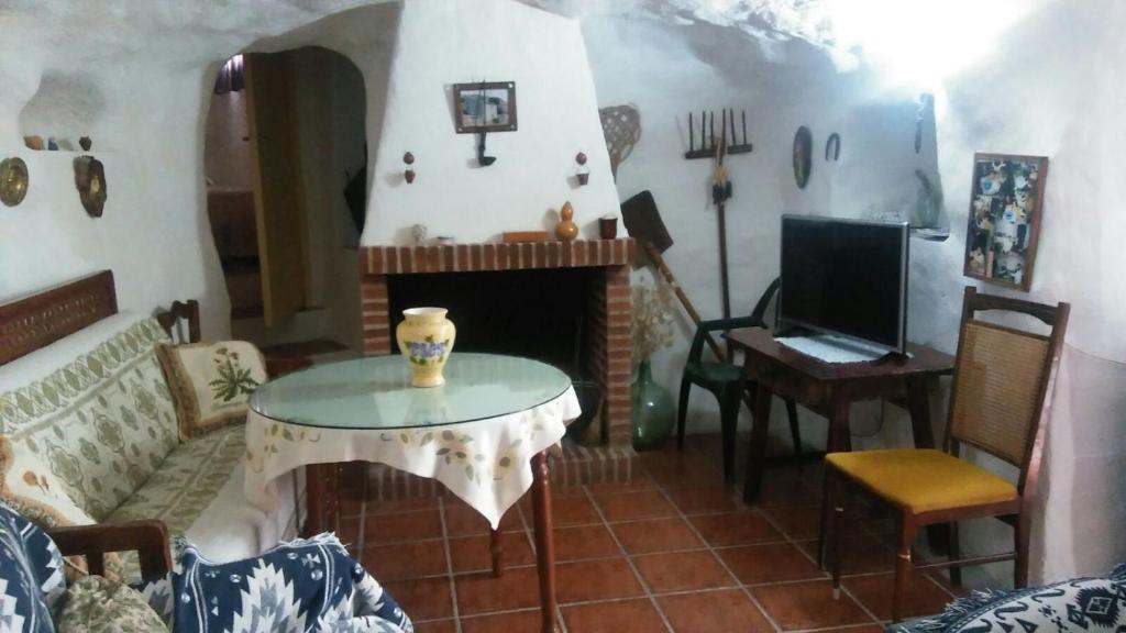 PegalajarCueva Rural La Noguera的客厅配有桌子和壁炉