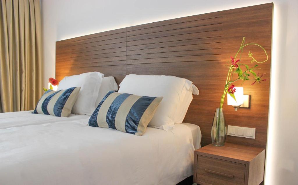 奥斯特豪特A-Hotel Oosterhout的一间卧室配有一张大床和木制床头板