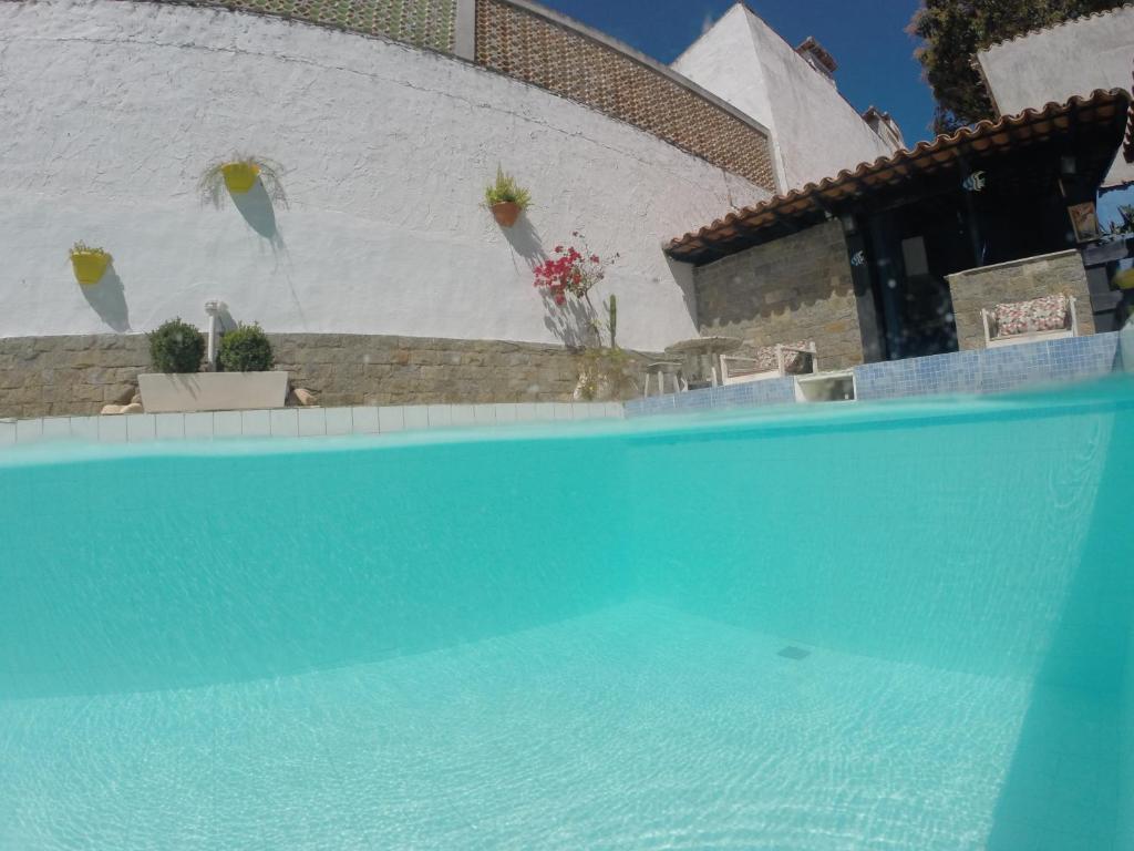 卡波布里奥Rock n Hostel的白色墙壁前的蓝色游泳池