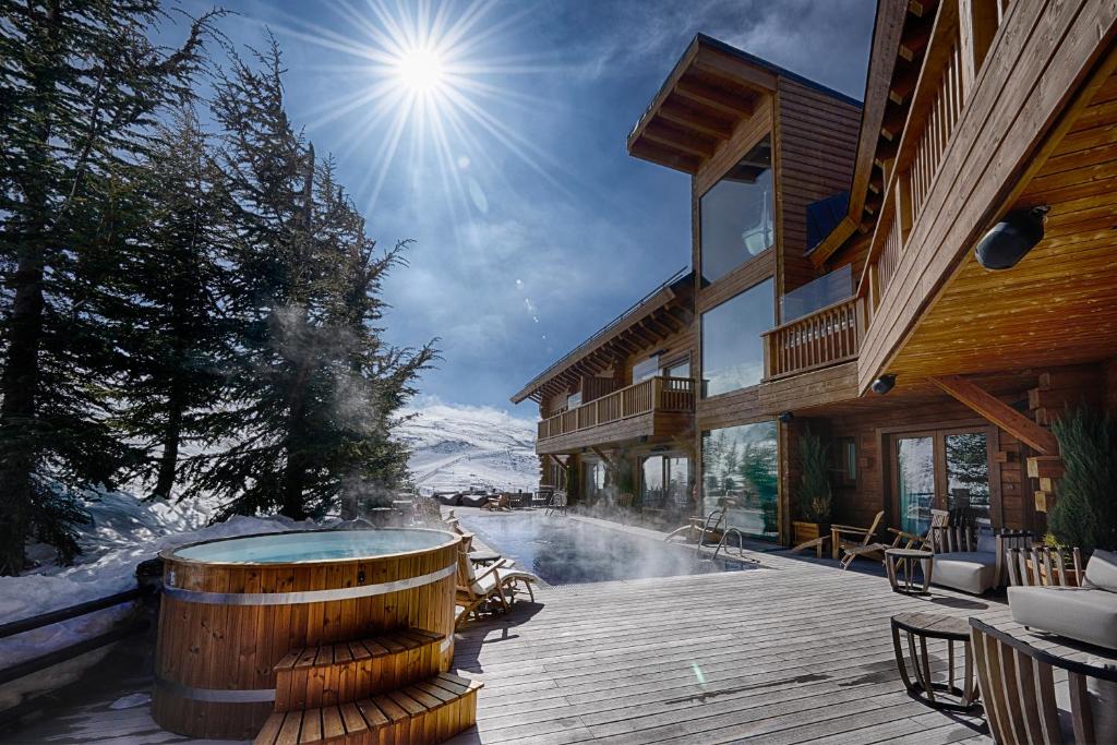 塞拉内华达厄尔滑雪Spa酒店的大楼旁甲板上的热水浴池