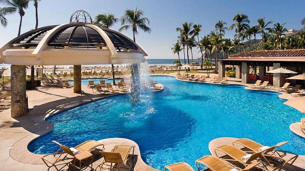 阿卡普尔科Pierre Mundo Imperial Riviera Diamante Acapulco的一个带椅子的游泳池和一个喷泉