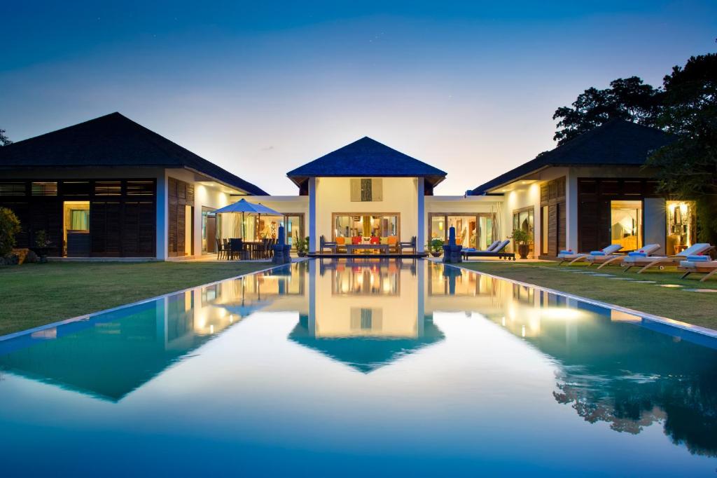 海神庙Bali Luxury Boutique Resort and SPA的一座房子前面设有游泳池