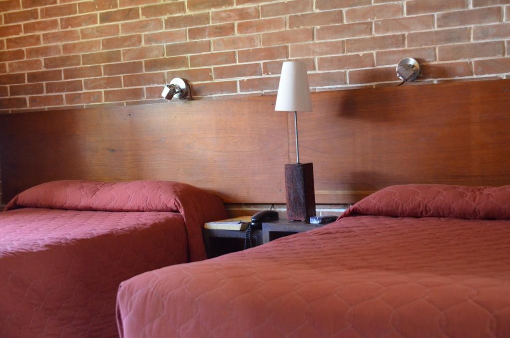 危地马拉戴诺尼酒店的酒店客房带两张床和砖墙