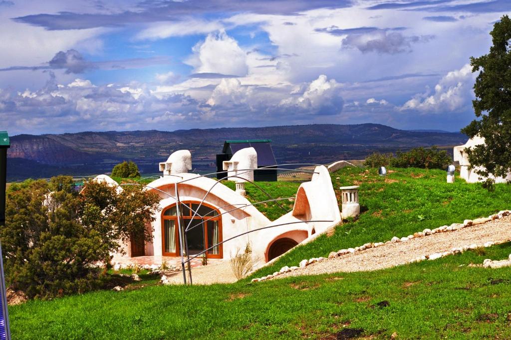 Albalate de ZoritaHotel Rural & Spa Las Nubes的青草山顶上的房子