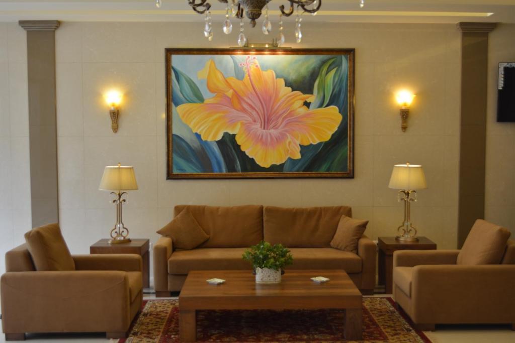 贝鲁特Bella Rosa Hotel的客厅配有沙发和一幅花画