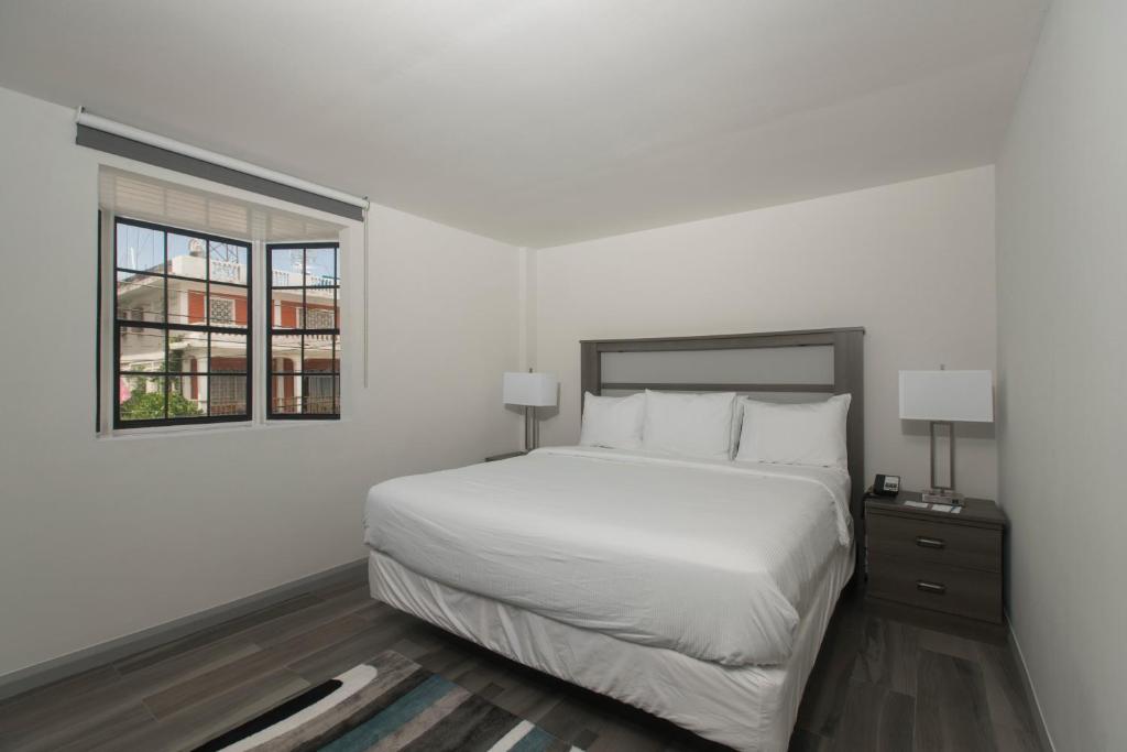 乔治敦金斯酒店的白色的卧室设有床和窗户