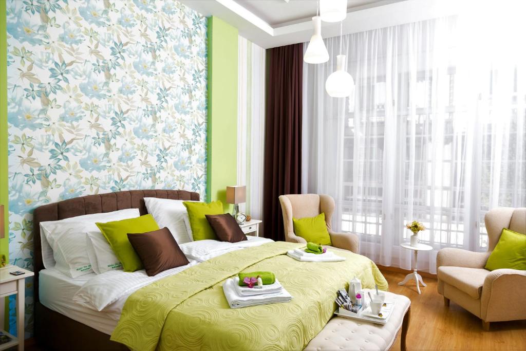 布达佩斯布达佩斯麦克斯哈皮公寓的一间卧室配有一张床、一张沙发和椅子