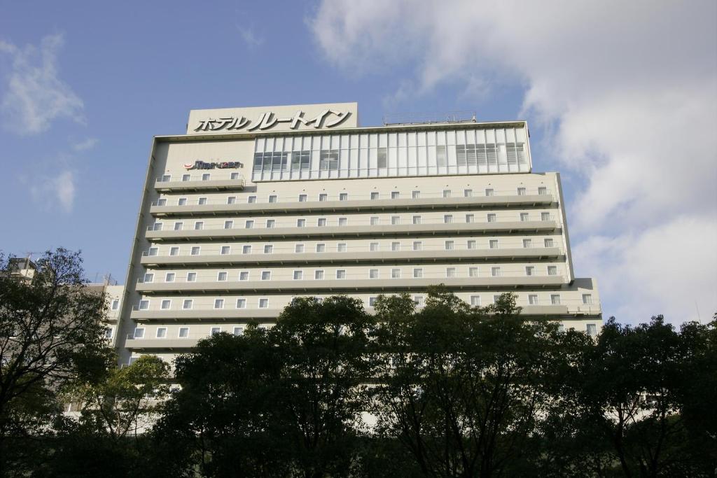 大阪大阪本町路线客栈酒店的一座白色的大建筑,上面有标志
