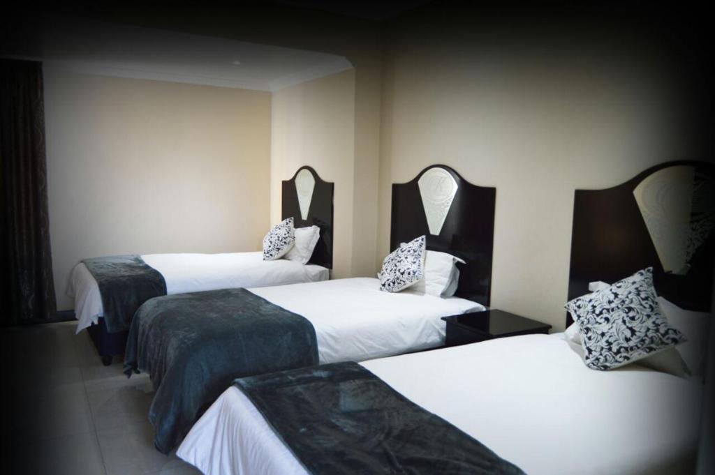 彼得马里茨堡Kismet Hotel的酒店客房带两张床和两面镜子