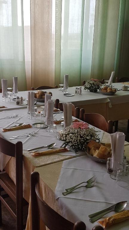 卡萨尔马焦雷Hotel La Favorita的一组桌子,上面有白色的桌布和盘子