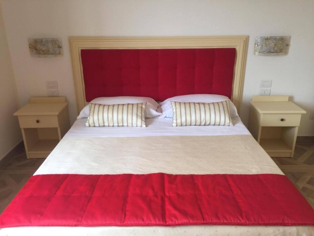奇维泰拉-德尔特龙托Il Salice的一间卧室配有一张大床和红色床头板