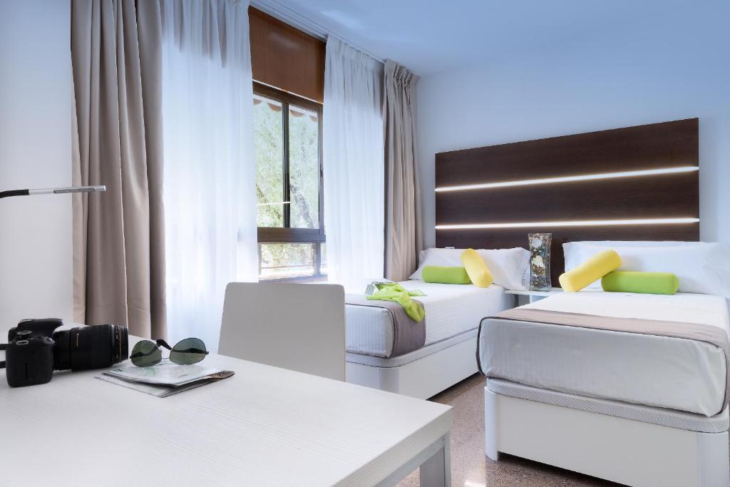 马德里Roisa Hostal Boutique的一间带两张床和一张沙发的客厅