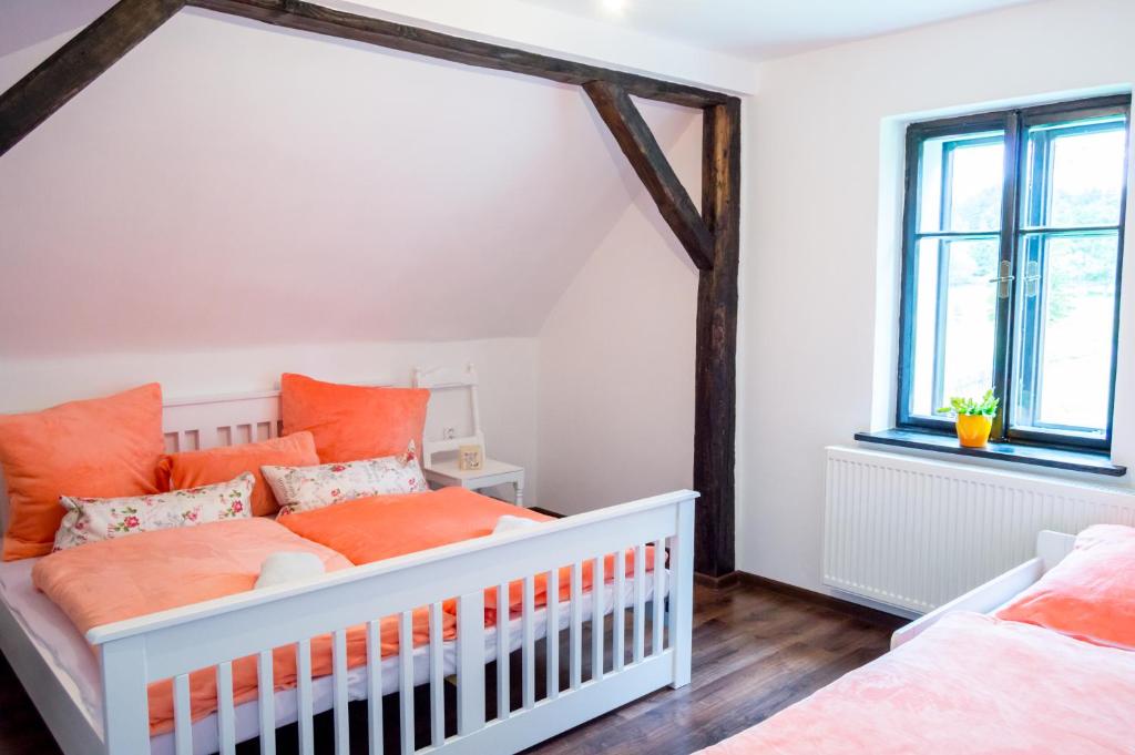金日瓦特矿泉镇Apartment-Chalet-Chaloupka U Trnků的一个带婴儿床和橙色枕头的托儿所