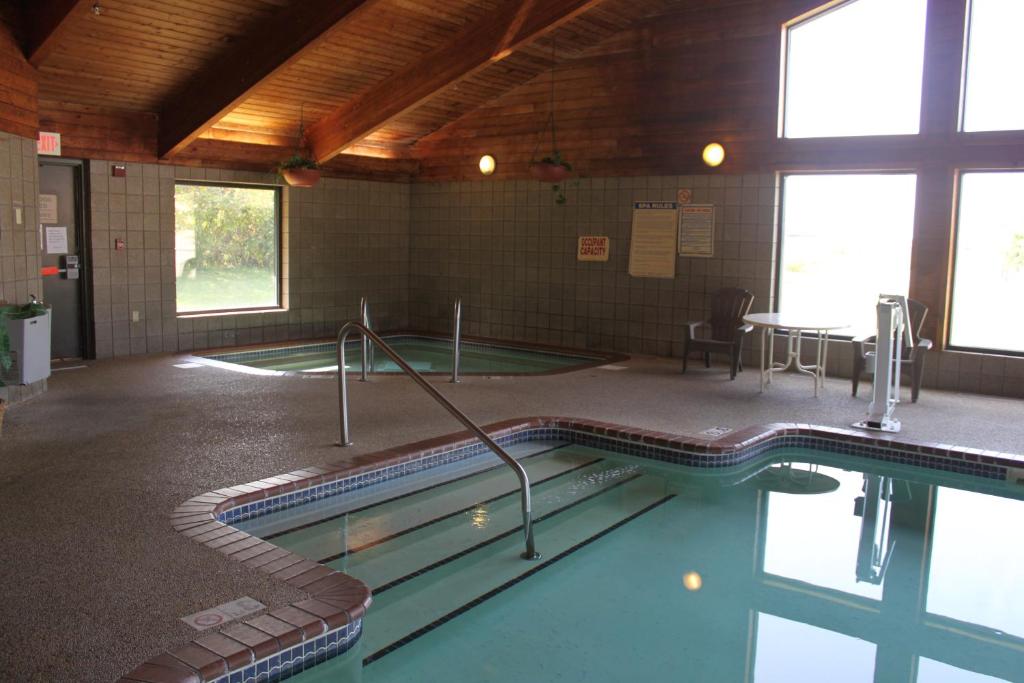 West Burlington西伯灵顿阿美瑞辛酒店的一座带桌椅的游泳池