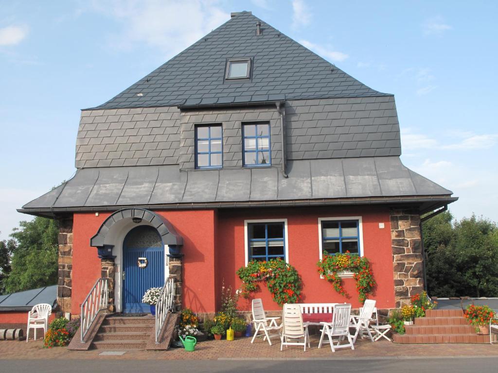 库罗阿尔滕堡Beerenvilla的红色的房子,带长 ⁇ 屋顶,配有桌椅