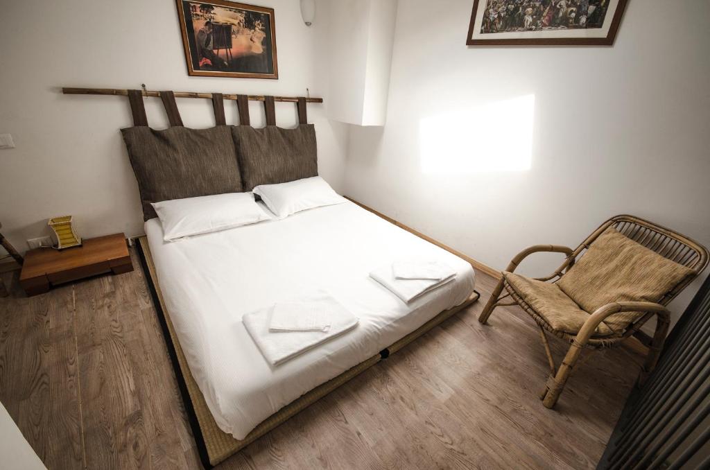 博洛尼亚Sigismondo apartment的一间小卧室,配有一张床和一把椅子