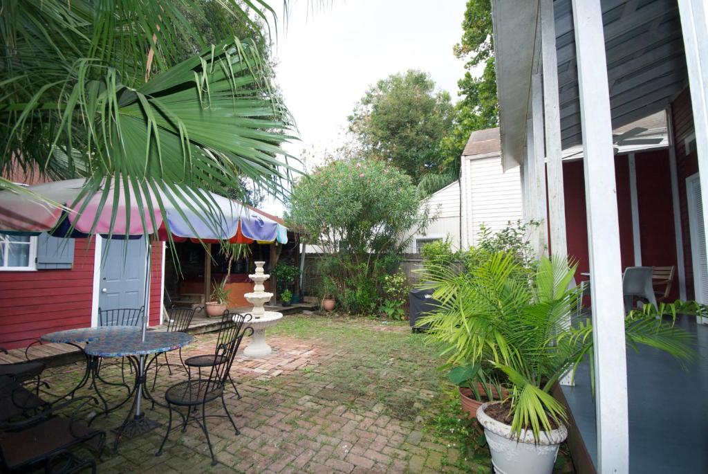 新奥尔良勃艮第住宿加早餐酒店的庭院配有桌椅和遮阳伞。