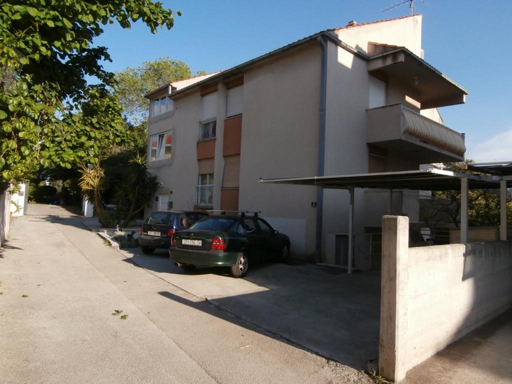 斯普利特Apartment studio Mia-beach in Split的停在大楼旁边的停车场的汽车