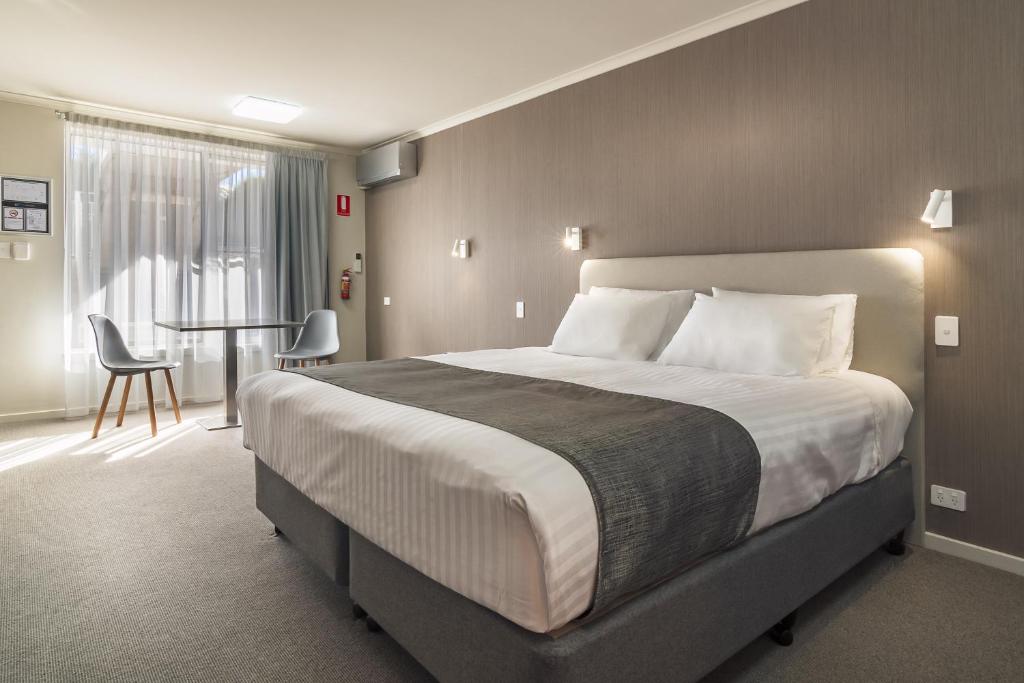 德文港阿戈汽车旅馆 的酒店客房设有一张大床和一张桌子。