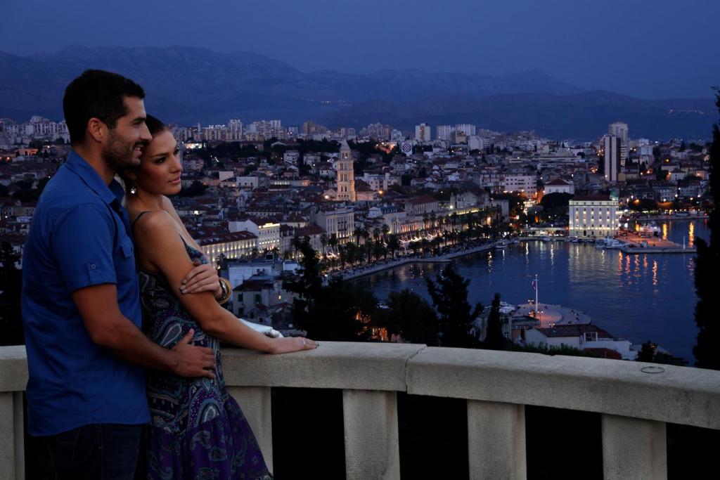 斯普利特S Luxury Apartments的站在俯瞰城市的阳台的男女
