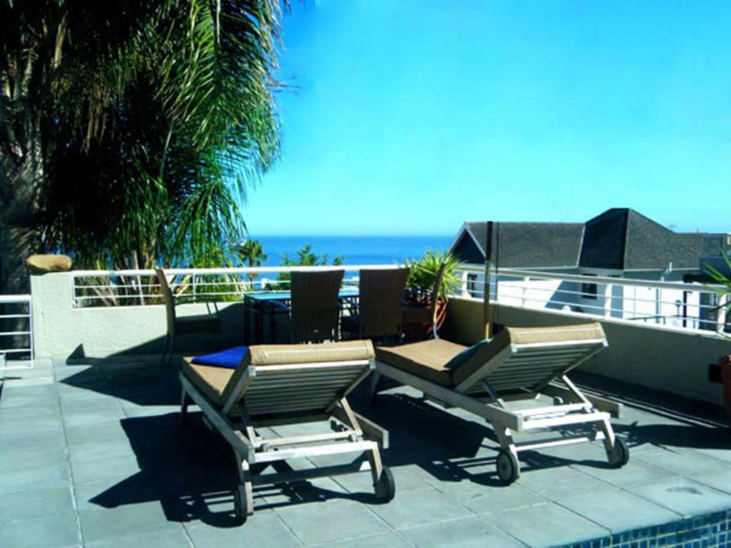 开普敦枫丹白露庄园酒店的海景庭院设有两把椅子和一张桌子