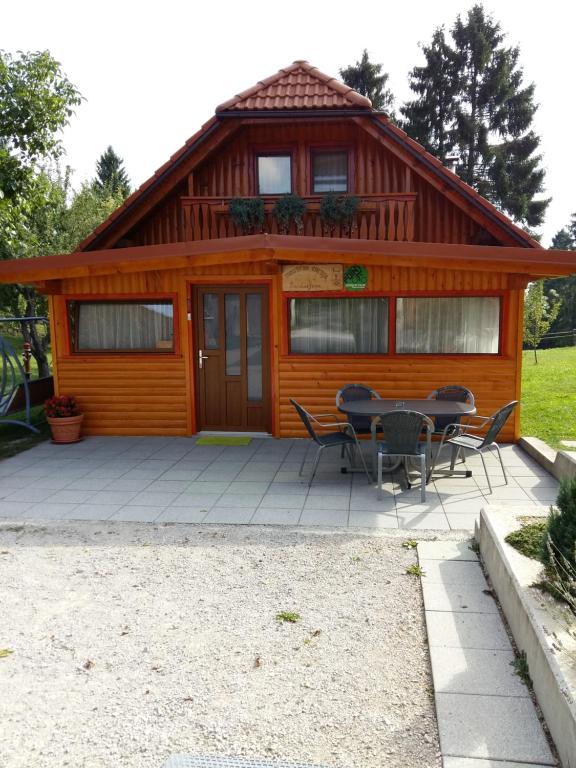 KožljekTourist Farm Znidarjevi的小屋前方设有桌椅