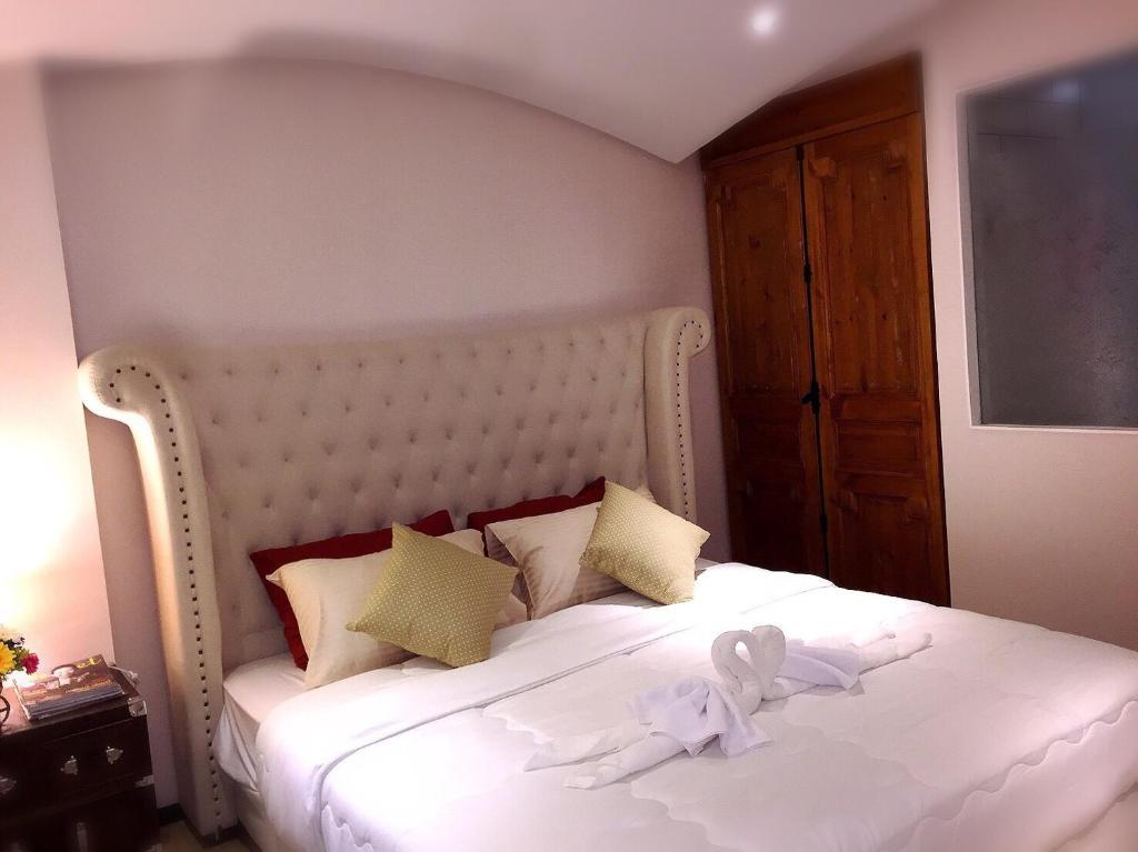乔木提恩海滩Venetian Signature PoolAccess Resort Jomtian Pattaya的卧室配有一张白色的床,上面有一只动物填充物