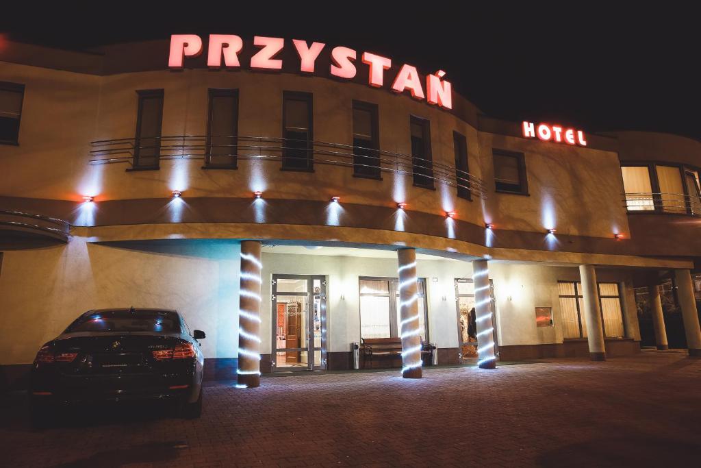 卢布林Restauracja Hotel Przystan的晚上停在酒店门前的汽车