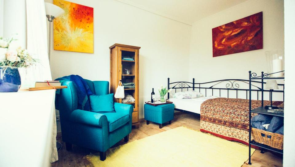 胡苏姆Das Blaue Haus的一间卧室配有蓝色椅子和一张床