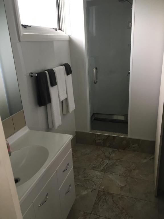 哈韦拉Mount View Motel Hawera的浴室配有盥洗盆、淋浴和毛巾