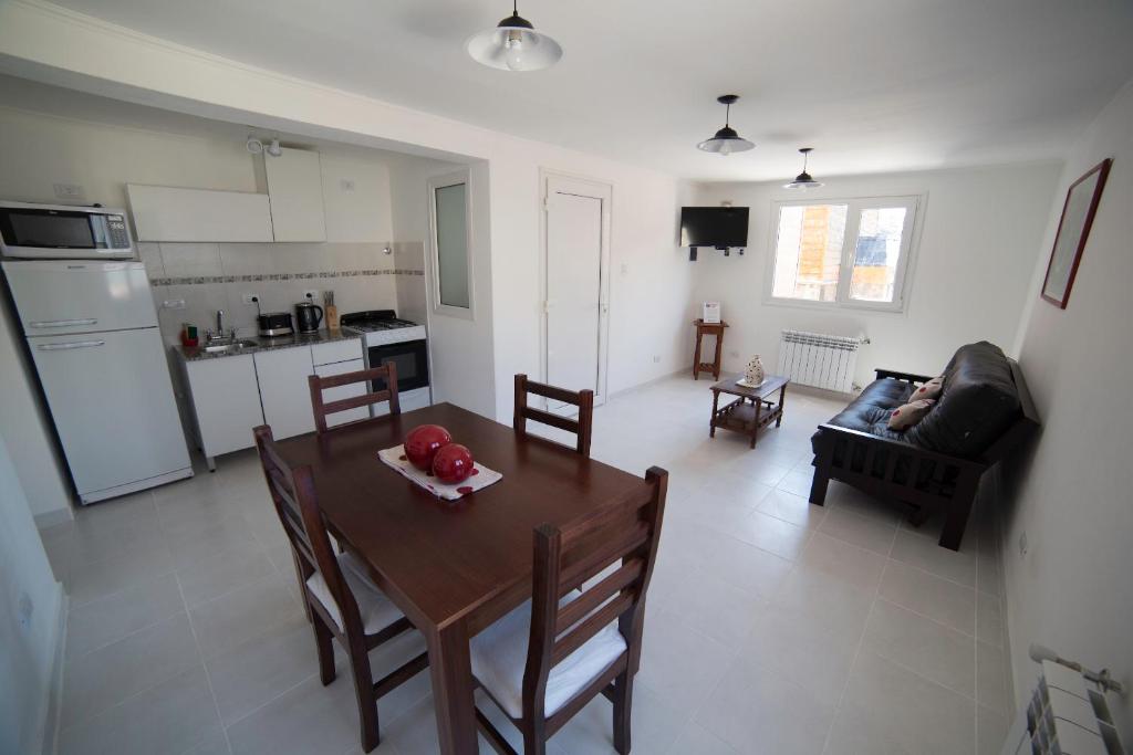 科帕韦Aparthotel Aldea Termal的厨房以及带桌椅的起居室。