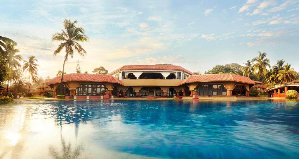 坎多林果阿泰姬堡阿瓜达度假酒店的一座带游泳池的度假村,位于一座建筑前