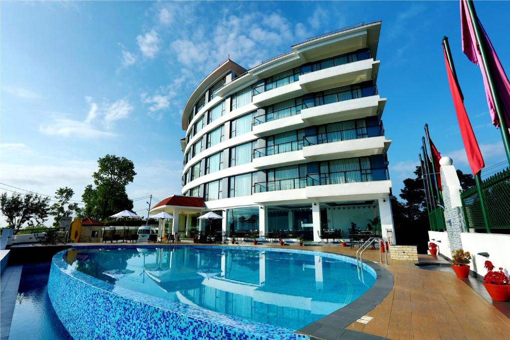 博卡拉Himalayan Front Hotel by KGH Group的大楼前设有游泳池的酒店