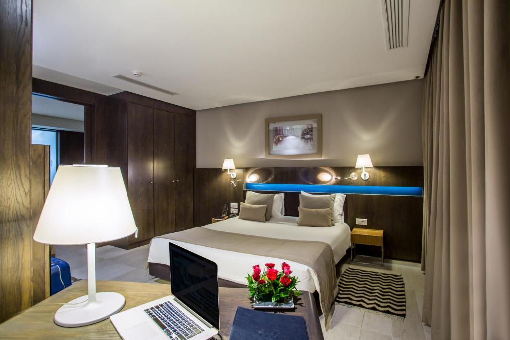突尼斯贝维德夫拉提酒店的酒店客房配有一张床、一张书桌和一台笔记本电脑