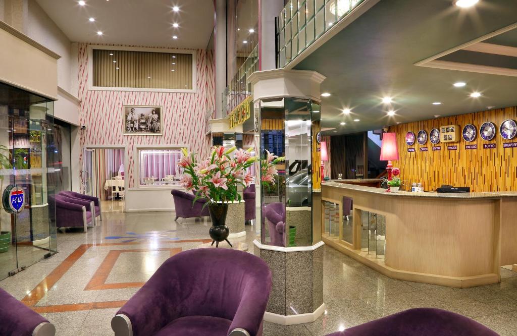 清迈高速公路酒店的大堂设有紫色椅子,商店设有酒吧