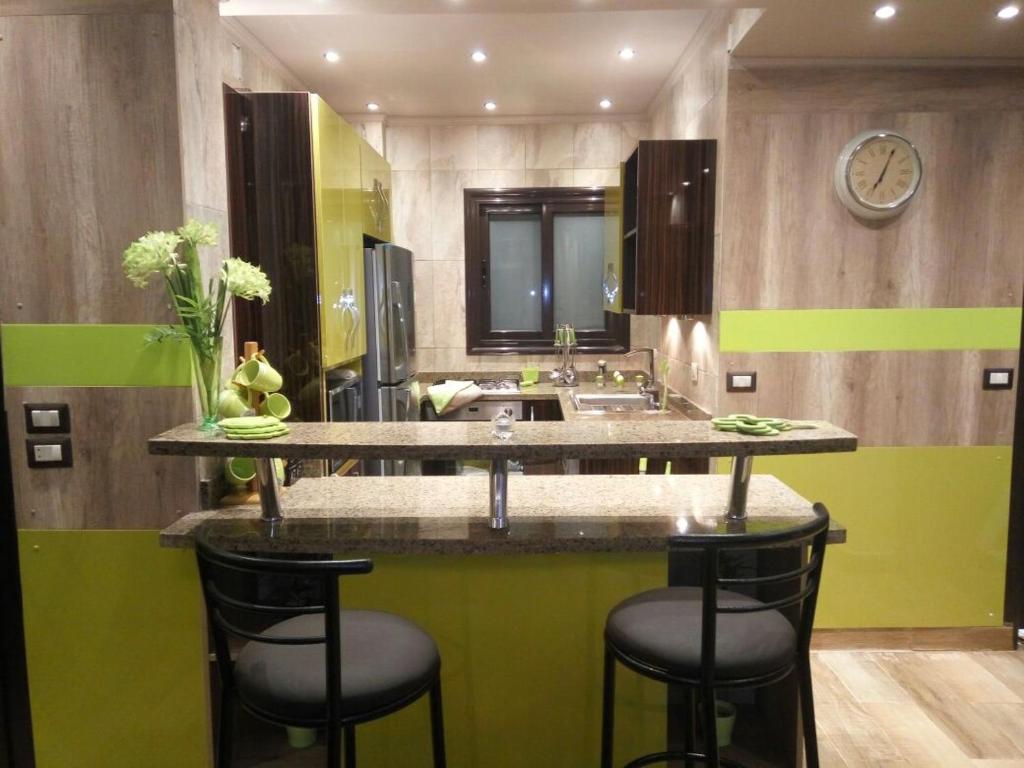 亚历山大Luxury Mamoura Alexandria Apartment的浴室设有水槽和带凳子的台面。