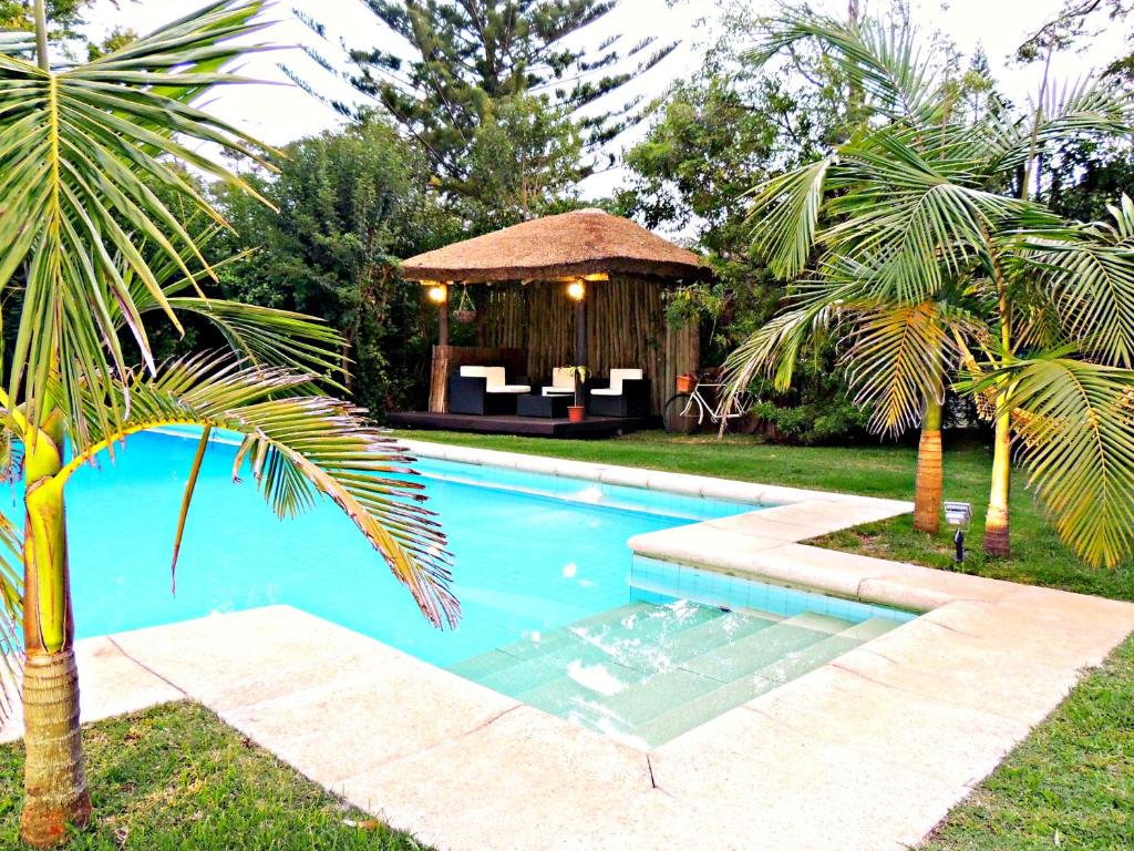 埃斯特角城珀蒂堡精品酒店的一个带凉亭和棕榈树的游泳池