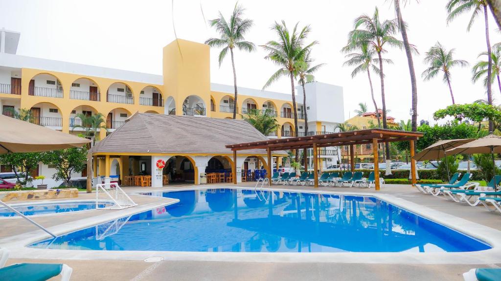 瓜亚比托斯科斯塔阿莱格里酒店及套房的棕榈树酒店前的游泳池