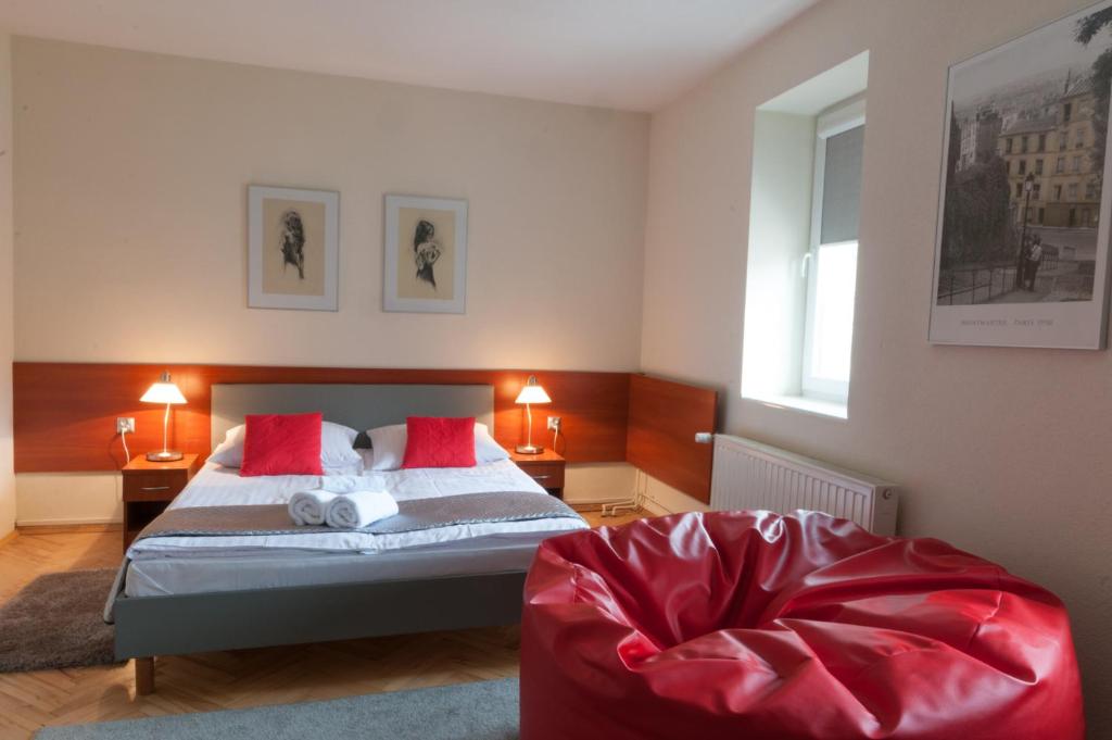 斯卡日斯科-卡缅纳科美思酒店的一间卧室配有一张床和一张红色椅子